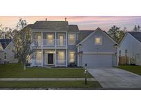 Two-story house with gray siding, a white porch, and a two-car garage at 1565 Ashley Garden Blvd, Charleston, SC 29414