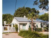 Charming white cottage with metal roof, green door, and landscaped yard at 207 Scott St, Mount Pleasant, SC 29464