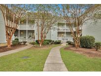 Attractive courtyard with walking paths, landscaping, and two-story building with balconies at 2347 Tall Sail Dr # J, Charleston, SC 29414