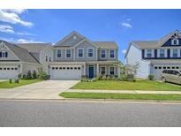Two-story home with gray siding, two-car garage, and landscaped lawn at 113 Corvus St, Summerville, SC 29483