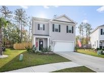 Two-story house with gray siding, a white garage door, and a well-maintained lawn at 671 Silver Spruce St, Summerville, SC 29486
