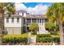 Charming two-story home with a metal roof, screened porch, and landscaped yard at 2220 Ion Ave, Sullivans Island, SC 29482
