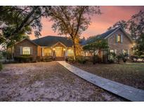 Brick home with walkway, landscaping, and a sunset view at 122 Cainhoy Landing Rd, Charleston, SC 29492