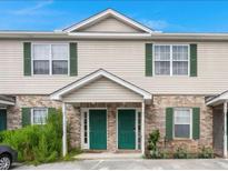 Two-story tan duplex with green shutters and doors at 148 Pine Shadow Dr, Goose Creek, SC 29445