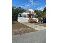 Two-story beach home with wrap-around porch and spacious yard at 2305 Myrtle St, Edisto Beach, SC 29438