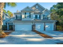 Tan three-story townhome with three-car garage and landscaping at 5150 Trump St # 1905, North Charleston, SC 29420