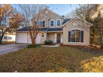 Two-story stucco home with a two-car garage and landscaped lawn at 7011 Windmill Creek Rd, Charleston, SC 29414