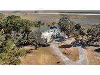 Aerial view of a waterfront home with a long driveway, showcasing its serene location at 9681 Two Pines Rd, McClellanville, SC 29458