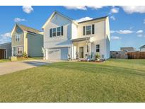 Two-story white house with a green door, landscaping, and a two-car garage at 432 Eva St, Moncks Corner, SC 29461