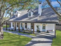 Charming farmhouse exterior with a gray roof, white siding, and a welcoming front porch at 715 King St, Mount Pleasant, SC 29464