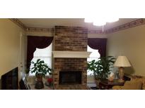Living room with brick fireplace, large windows, and plush armchair at 141 Wintergreen Rd, Walterboro, SC 29488