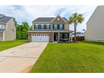 Inviting front yard with a hammock under a palm tree, leading to a two-story home at 202 Lab Ct, Moncks Corner, SC 29461