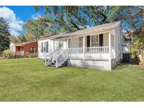 Charming white home with covered front porch and lush green lawn at 2754 Houston St, North Charleston, SC 29405