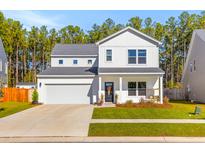 Charming two-story home with a welcoming front porch and landscaped yard at 4312 Cotton Flat Rd, Summerville, SC 29485