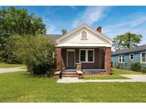 Charming brick home with a covered front porch and landscaped yard at 1808 Calvert St, North Charleston, SC 29405