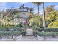 Two-story home with a red door, iron gate, and landscaped yard at 208 Sumter Ave, Summerville, SC 29483