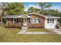 Brick ranch home with a white side, landscaped lawn, and driveway at 2578 Ridgewood Ave, Charleston, SC 29414