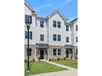 Three-story townhome with white siding, gray accents, and landscaping at 5142 Double Eagle Lp, Summerville, SC 29485