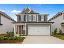 Two-story gray house with white garage door and landscaping at 318 Abercom Place Dr, Moncks Corner, SC 29461