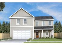 Two-story house with beige siding, a white garage door, and landscaping at 5876 Hwy 165, Ravenel, SC 29470