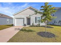 Newly constructed home with a white exterior, landscaped lawn, and driveway at 120 Clear Tide Dr, Summerville, SC 29486