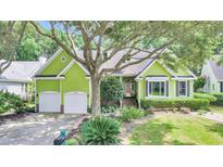 Charming lime green house with lush landscaping and two-car garage at 1287 Hogans Aly, Mount Pleasant, SC 29466