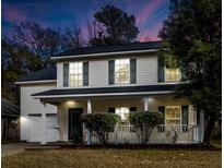Two-story house with a front porch, attached garage, and landscaped yard at 238 Trickle Dr, Summerville, SC 29483