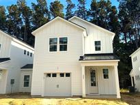 Two-story white farmhouse-style home with black metal roof and attached garage at 484 Queenview Ln, Charleston, SC 29414