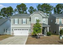 Two-story house with gray siding, stone accents, and a two-car garage at 158 Emerald Isle Dr, Moncks Corner, SC 29461