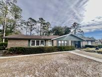 Ranch style home with brick facade, green shutters, and well-manicured landscaping at 208 Howard St, Varnville, SC 29944