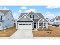 Gray two-story house with white garage door and front porch at 655 Black Pine Rd, Moncks Corner, SC 29461