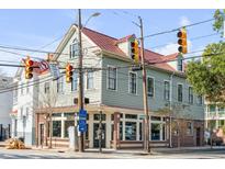 Charming two-story home with a light gray exterior and red roof at 132 Spring St, Charleston, SC 29403