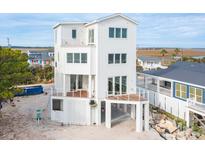 Elevated view of a three-story beach home with expansive decks at 1579 E Ashley Ave, Folly Beach, SC 29439