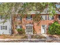 Brick townhouse with white door, landscaping, and tree shade at 172 Heritage Cir # L-4, Mount Pleasant, SC 29464