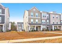 Three-story townhome with neutral siding and landscaping at 352 Herty Park Dr, Moncks Corner, SC 29461