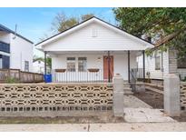 Charming white cottage with a coral door, concrete walkway, and a decorative block wall at 31 Allway St, Charleston, SC 29403