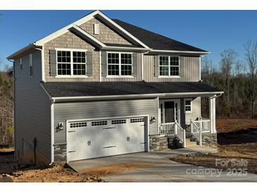 Two-story house with gray siding, stone accents, and a two-car garage at 117 High Rock Ct # 09, Statesville, NC 28677