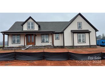 Newly constructed farmhouse-style home with gray stone accents and a covered porch at 1405 Coppergate Dr, Salisbury, NC 28147