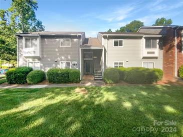 Gray two-story condo building with green lawn and walkway at 3021 Heathstead Pl # D, Charlotte, NC 28210