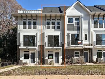 Modern 3-story townhome with brick and white siding, attached garage, and front yard at 1211 E 34Th St # Csw0313, Charlotte, NC 28205