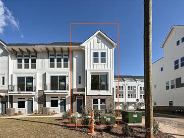 Modern three-story townhome with white siding and gray accents at 1219 E 34Th St # Csw0317, Charlotte, NC 28205