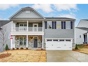 Charming two-story home with a gray exterior, white trim, and a covered front porch at 130 Summerhill Dr # 16, Mooresville, NC 28115