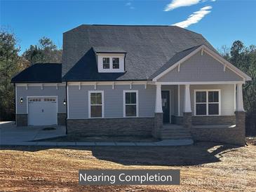 Two-story home with gray siding, stone accents, and a three-car garage at 515 Edmunds Ln # 38, Clover, SC 29710