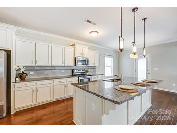 Island kitchen with granite countertops and white cabinets at 1108 Bannockburn Ave, Rock Hill, SC 29732