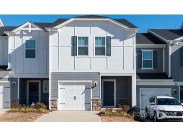 Two-story townhome with gray and white siding, white garage door, and landscaping at 3820 Shider Ln, Kannapolis, NC 28081