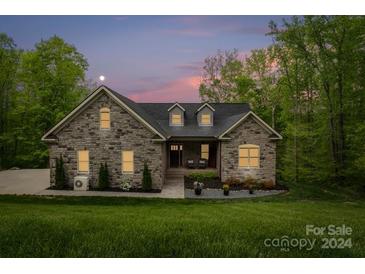 Stone house exterior at dusk, with landscaping and a driveway at 111 Dockside Ln, Statesville, NC 28677