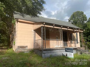 Older fixer-upper home with a porch and needs significant renovations at 303 Ray St, Lancaster, SC 29720