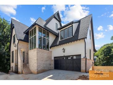 Two-story home with a brick and white exterior, and a two-car garage at 7010 Chateau Bordeaux Ln, Charlotte, NC 28270