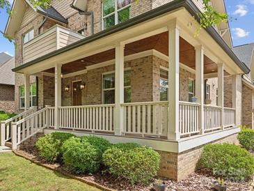 Two story home with a welcoming front porch and landscaping at 7239 Sheffingdell Dr, Charlotte, NC 28226