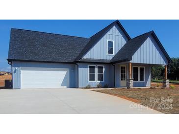 Modern farmhouse style home with gray siding and a covered porch at 32553 Buchanan Ln, Albemarle, NC 28001